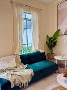 a living room with a green couch in front of a window at Sakna Mérida con jacuzzi alberca privada in Mérida +86 photos