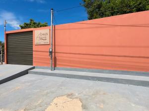 a orange garage door with a sign on it at Chalés Areias in Barreirinhas +4 photos
