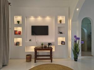 a living room with a table and a tv on a wall at ROHO-Residence in Nungwi