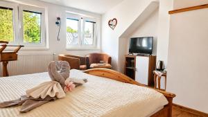 a bedroom with a bed and a tv and windows at Vila Harmónia in Turčianske Teplice