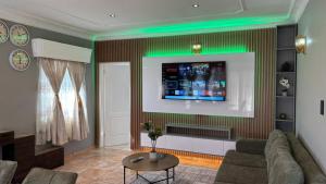 a living room with a couch and a television on a wall at Bella Vista in Edenvale