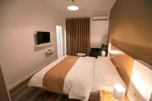a hotel room with a bed and a television at Hotel Sidi in Tirana