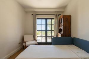 a bedroom with a bed and a chair and a window at Viento Villa in Çeşme +38 photos