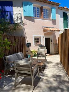 a patio with a couch and a table in front of a house at Petite maison de pecheur in Grimaud