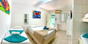a room with two beds and a bathroom at Pousada Brasil Natal in Natal