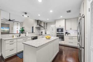 a kitchen with white cabinets and a counter with a bowl of fruit at The Summer House - Private Pool Firepit in Jacksonville