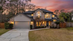 a house with a garage in a yard at The Summer House - Private Pool Firepit in Jacksonville