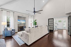 a living room with a couch and a ceiling fan at The Summer House - Private Pool Firepit in Jacksonville