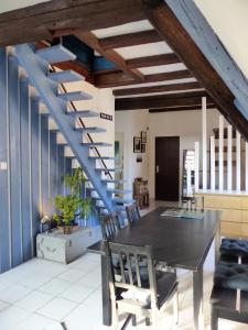 a dining room with a table and a blue staircase at La Venise bleue in Colmar