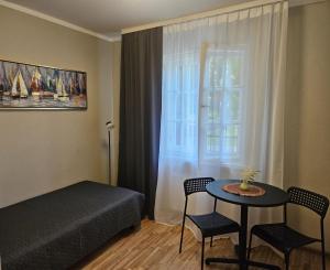 a bedroom with a bed and a table and a window at B5 Jurmala Apartments in Jūrmala