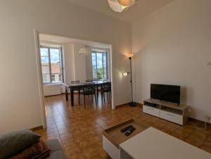 a living room with a table and a television at Appartement du parc in Ambert