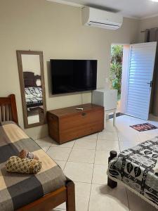 a living room with a flat screen tv on the wall at Na Boca do Jacaré in Caraguatatuba
