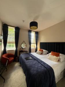 a bedroom with two beds and a chair and window at The courtyard bar, kitchen, rooms in Falkirk