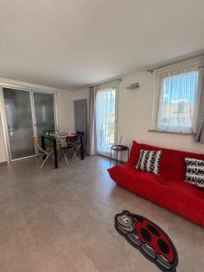 a living room with a red couch and a table at Casa Cocci in Aosta