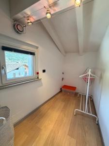 an empty room with a window and a wooden floor at Casa Cocci in Aosta