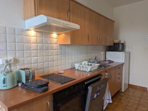 a kitchen with wooden cabinets and a counter top at Appartement du parc in Ambert +10 photos