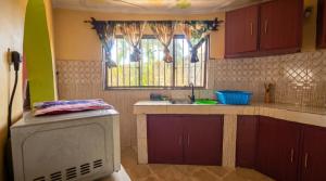 a small kitchen with a sink and a window at Mnchunge's Residence in Kikambala
