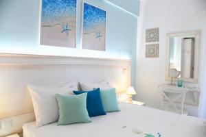 a bedroom with a bed with blue and white pillows at El Greco Nei Pori in Nei Poroi