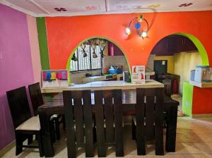 a dining room with a table and a kitchen at Mnchunge's Residence in Kikambala +5 photos