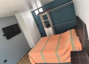 a small bedroom with a bed and a tv at Loft Privado Seguridad 24HRS a 15 de piramide de cholula in Cholula