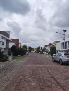 a cobblestone street with a car parked on it at Loft Privado Seguridad 24HRS a 15 de piramide de cholula in Cholula