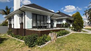 a white house with a porch and a yard at Bella Vista in Edenvale