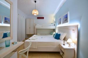 a white bedroom with a white bed and a desk at El Greco Nei Pori in Nei Poroi