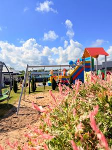 a playground with a play equipment in the sand at Holiday Camp Sarbinowo in Sarbinowo