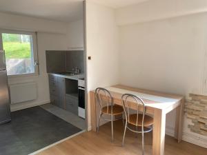 a kitchen with a wooden table and two chairs at Chez Aurele in Villersexel