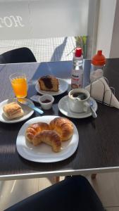 a table with plates of pastries and a cup of coffee at Hotel Andino in La Rioja
