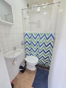 a bathroom with a toilet and a sink at Praia Morro Katia apartamentos - Edificio Franklin Storck in Guarapari