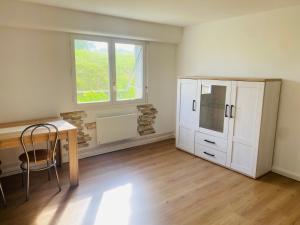 a room with a desk and a cabinet and a window at Chez Aurele in Villersexel