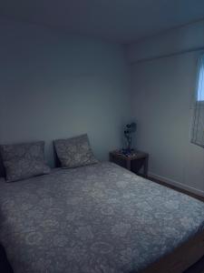 a bedroom with a bed and a table with a window at Chez Aurele in Villersexel