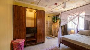 a bedroom with a canopy bed and a shower at Mnchunge's Residence in Kikambala