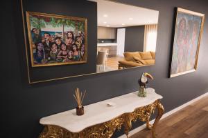 a living room with a table and a painting on the wall at Royal Galla Apartment in Macedo de Cavaleiros