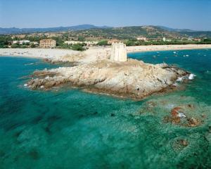 an island in the ocean with a lighthouse on it at Bari Sardo Suite Padronale in Bari Sardo