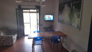 a dining room with a wooden table and blue chairs at Casa Betta in Stintino