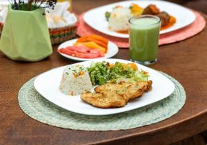 a table with plates of food and a glass of green juice at Cinco de Mayo Hotel in Querétaro
