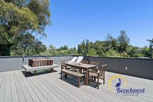 a deck with a table and chairs and a bench at Coastal Treehouse in Aptos +56 photos