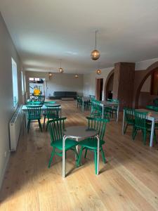 a room with green chairs and tables in a building at Albi's Sandvig Boutique Hotel in Sandvig