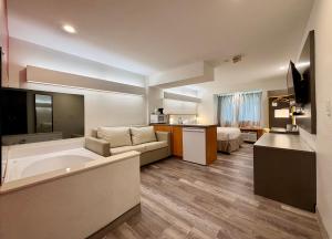 a hotel room with a large tub and a couch at Ramada Limited Bloomington IL I-74/I-55 in Bloomington