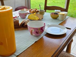 a table with a breakfast of bread and coffee cups at Le Relais de Saint Germain in Saint-Germain-les-Belles