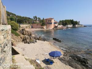 a beach with a blue umbrella on the sand at Camping les Lauriers Roses in Fréjus
