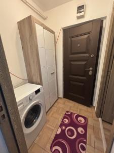 ein Waschraum mit Waschmaschine und Tür in der Unterkunft MiMa Home in Roman