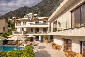 a hotel with a swimming pool and mountains in the background at Mamei Boutique Villa in Dobrota