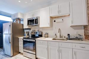 a kitchen with white cabinets and a stainless steel refrigerator at Brick house in Savannah
