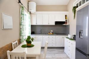 a kitchen with white cabinets and a white table at La Casita del Sur, Abades in Abades