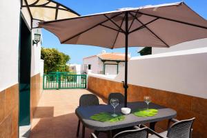 a patio with a table and an umbrella at La Casita del Sur, Abades in Abades