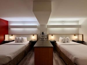 a hotel room with two beds and a desk at Ramada Limited Bloomington IL I-74/I-55 in Bloomington +39 photos