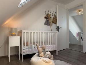 a baby room with a crib and a crib at Haus mit Herz in Wangerland